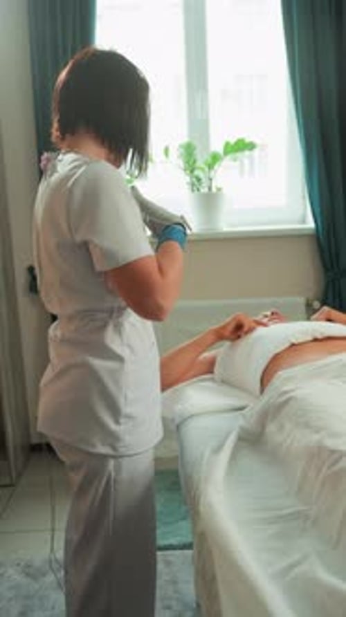 Woman Lying on Medical Bed, Cosmetologist With Gloves