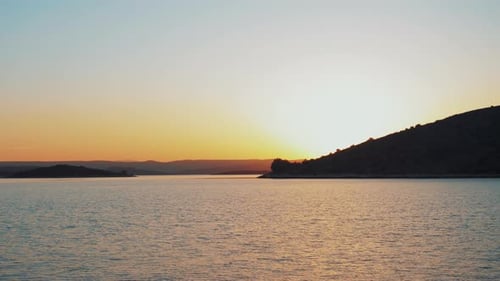 Ein schwelgender Shooting eines Sonnenuntergangs hinter einer kleinen Insel. Schöne und tolle Farben, romantische Zeit.