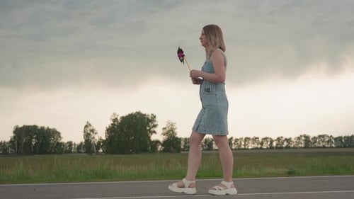 Side View Woman Walking with Colourful Pinwheel