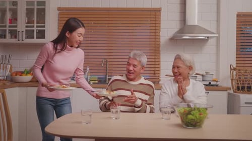 Woman Serving Meal to Family in Kitchen
