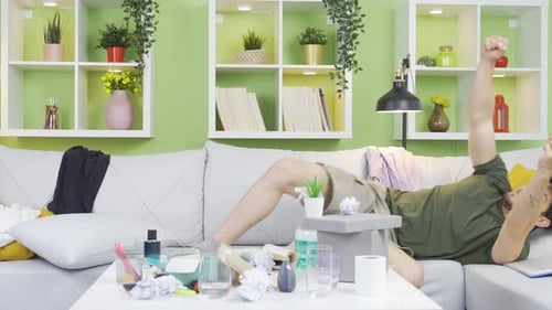 Man Celebrates Lying on Couch in Apartment