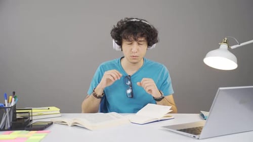 Teen Studying and Listening to Music at Desk