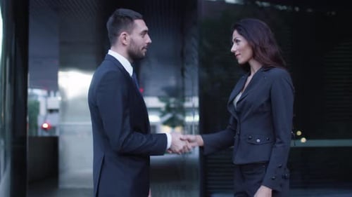 Business Man and Woman Handshake Outside Office Building