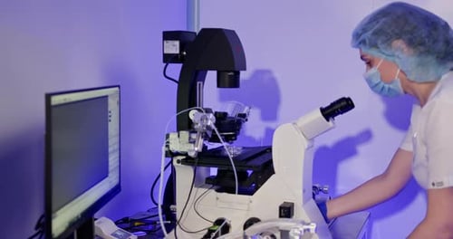 Medical Professional Using Microscope in Modern Laboratory