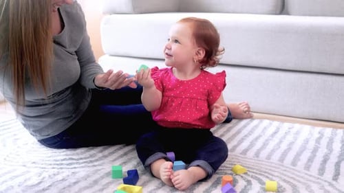Mother and Baby Play with Colorful Wooden Blocks