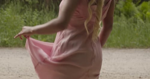 Black Girl With Blonde Hair, Wearing A Pink Gown, Stands By A Gravel Road In Forest. Close Up Shot