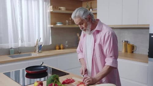 Senior Man Chopping Vegetables in Bright Kitchen