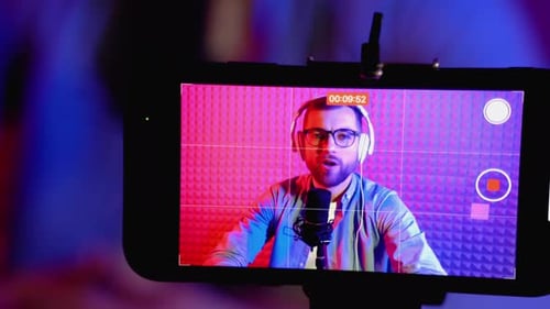 Man Recording Podcast with Microphone in Home Studio