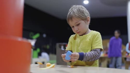 A Young Boy is Playing with a Toy in a Room