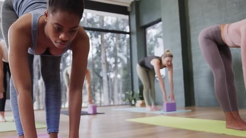 Young Adults Practicing Yoga in Bright Studio