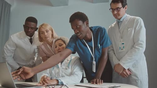 Medical Team Collaborates on Laptop in Hospital