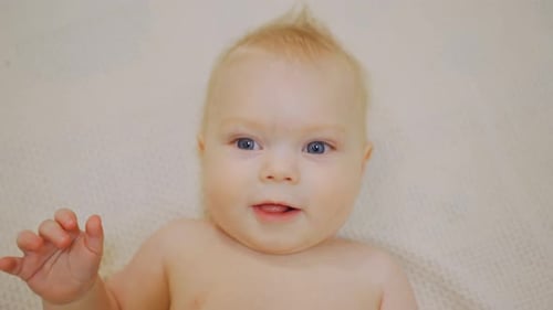 Porträt eines kaukasischen weißen Neugeborenen, schönes, charmantes, positives, gesundes Baby, Junge, Nahaufnahme, Gesicht