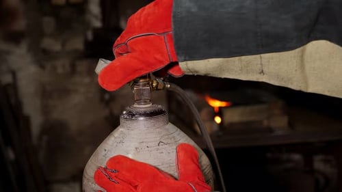 Person Adjusting Valve on Gas Cylinder