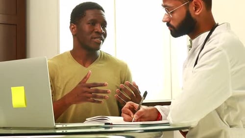 Doctor and Male Patient Talking at Office Consultation for Further Treatment