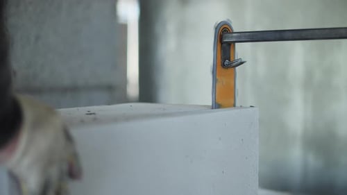 Worker Using Electric Saw to Cut Aerated Concrete Block
