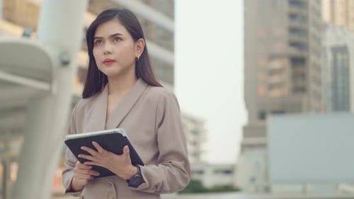 A young beautiful businesswoman is using tablet in Modern city
