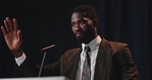 Man Speaking in a Suit in Front of Microphone