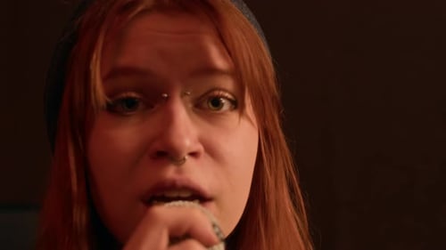 Portrait of Gen Z Girl with Piercing Singing Punk Rock Music into Microphone