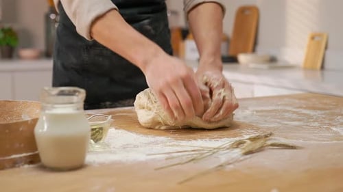Baker Kneading Dough in Sunny Kitchen
