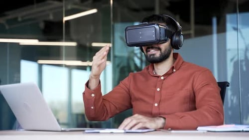 Successful businessman works using VR glasses in virtual reality simulator sitting at workplace