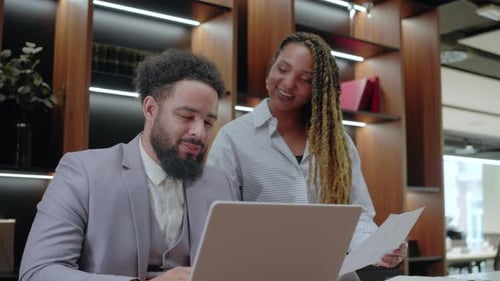 In a Collaborative Office an African American Businessman Shares Goals with a Colleague