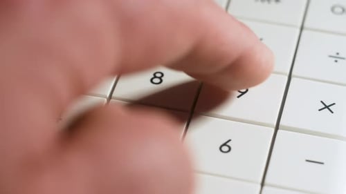 Hombre de cerca que trabaja con una calculadora para calcular datos comerciales y documentos contables en la oficina