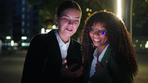 Smiling Women Looking at a Phone in the City