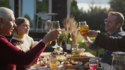 Family Gathered Around Table at Backyard Dinner Party