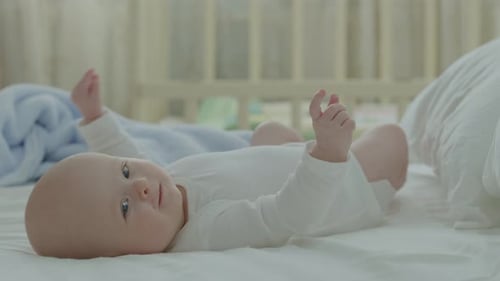 Happy Infant Kicking Legs on a Bed