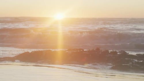 Video eines ruhigen Sonnenuntergangs über Meereswellen und Strand
