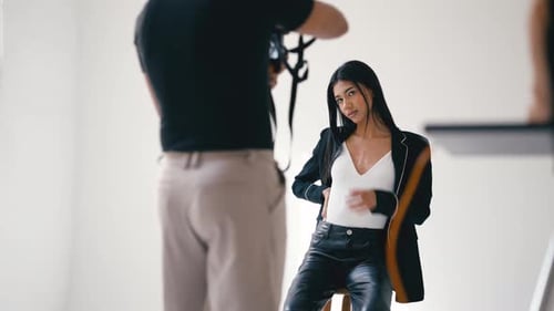 Professional Photographer Taking Pictures of Model Posing in Studio