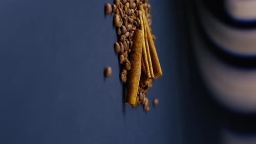 Vertikale Video-Nahaufnahme auf schwarzem und blauem Hintergrund Geröstete Kaffeebohnen liegen auf einem