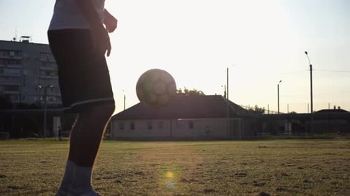 Legs of Young Man Kicking Ball at Green Field Male Feet of Professional Footballer Juggling Soccer