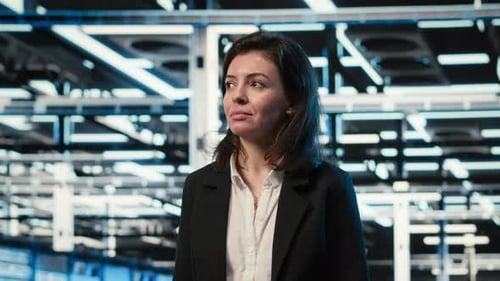 Smiling Manager Inspects Futuristic Data Center with Blue Wireframe Mesh Overlay