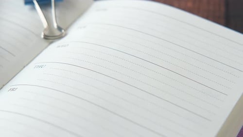Weekly Planner and Notepad on Table