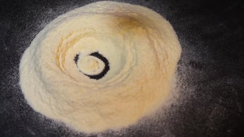Egg yolk falling into flour in slowmotion