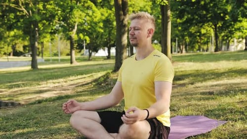 Man Meditating Peacefully in a City Park