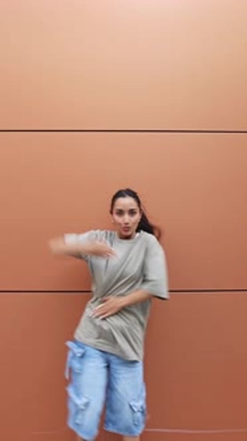 Stylish Woman Dancing in Front of Building