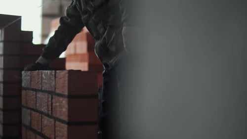 Construction Worker Laying Bricks for New Wall