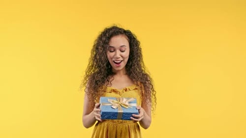 Woman Receives Birthday Gift on Yellow Background
