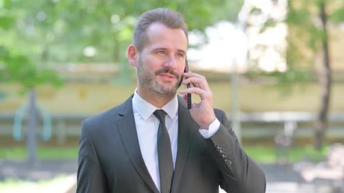 Man in Suit Talking on Phone Outdoors