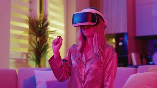 Woman in pajamas using VR headset in home