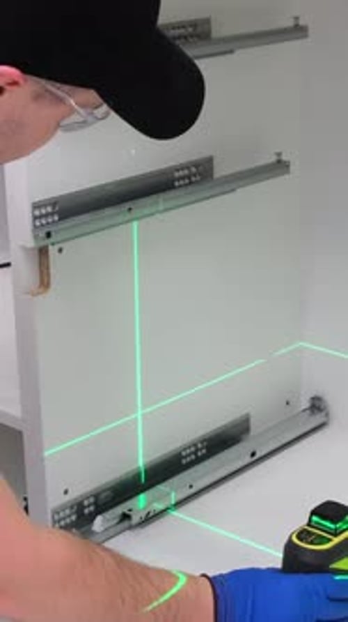 The Master Assembles Furniture for the Kitchen Using a Modern Electronic Level Vertical Video