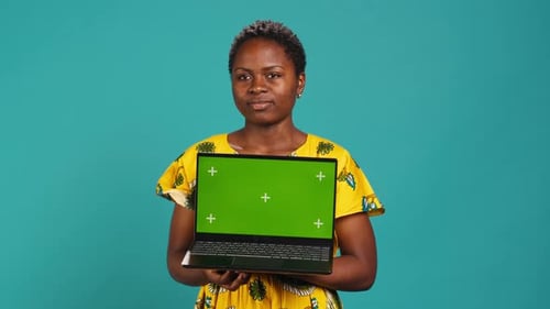 Optimistic Gorgeous Girl Holding a Pc with Isolated Green Screen