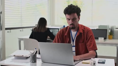 Portrait of Cheerful Office Worker Sitting in front of Laptop