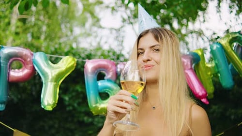 Smiling Woman Celebrating Birthday with Wine Outdoors