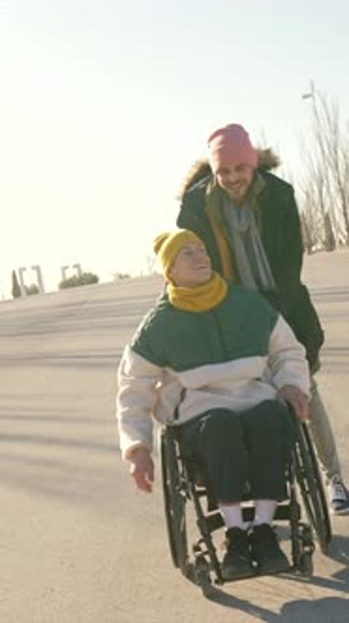 Friends Pushing Wheelchair Outside Smiling and Waving