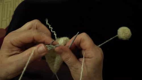 Grandmother Skillfully Handcrafting Woolen Socks with Spears, Infusing Comfort and Warmth from Natur