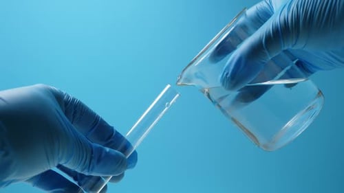 Transfunda el líquido de un tubo a un tubo de vidrio de ensayo de laboratorio Nobody Blue Tone