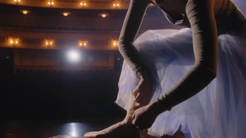 Ballet Dancer Ties Slippers Onstage in Theater